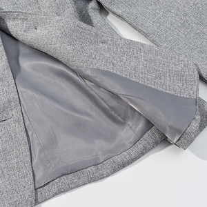 Detail showing cross-weave texture of grey blazer with smooth inner silk lining