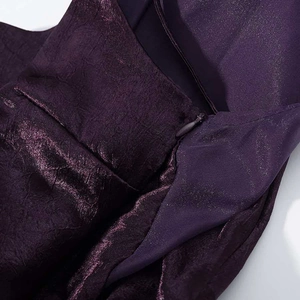 Detail of the invisible zipper and metallic textured fabric on deep purple dress