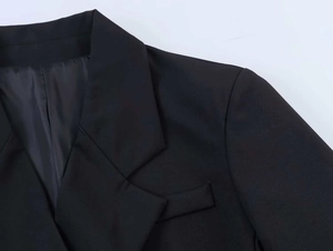 Detail of peaked lapel and black fabric texture on women's lace patchwork blazer