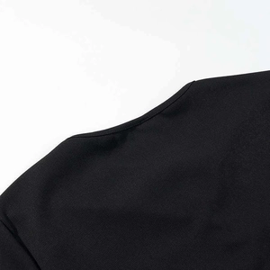 Close-up of the elegant round neckline on the black ribbed knit dress with neat stitching