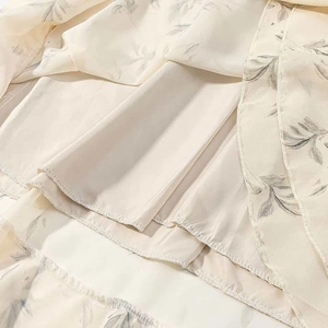Detail of floral chiffon dress hem featuring smooth light beige satin lining fabric