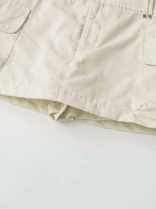 Détail d'une jupe-culotte cargo kaki montrant les poches latérales et rivets en métal