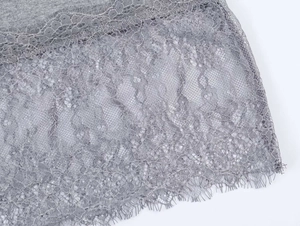 Detailansicht des hellgrauen Stricksaums mit feiner Wimpernspitze und floralen Mustern
