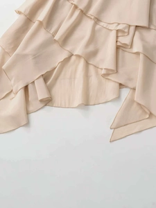 Detailed view of apricot layered ruffle hem with lightweight textured fabric finish