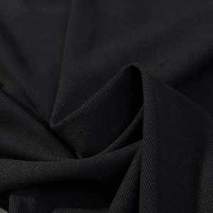 Close-up of the black lace dress fabric showing fine twill texture and premium material