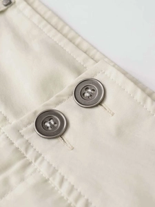 Détail de la fermeture à double bouton et coutures précises sur jupe cargo beige