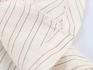 Detailed macro view of internal stitching on striped cotton-linen blazer fabric
