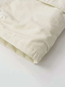 Détail de la jupe cargo trapèze crème montrant la texture sergé et la double couture
