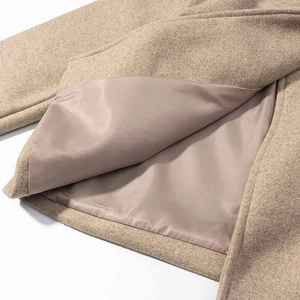 Detailed close-up of wool texture and premium satin lining on a camel autumn jacket