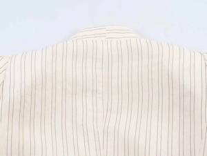 Detailed view of striped blazer neck and shoulder seams with precise fabric texture