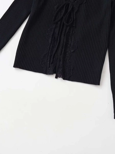 Detailed view of black ribbed knit top with delicate lace trim and adjustable drawstring