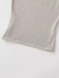Detail of high-density fine knit hem with smooth stitching on a grey knitted vest