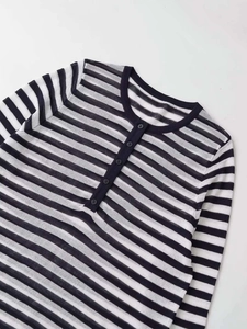 Close-up of the black and white striped knit texture and five-button Henley collar