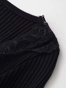 Detailed view of black ribbed knit fabric featuring elegant lace trim on the V-neckline