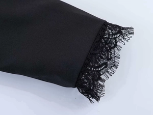 Close-up of black blazer sleeve with delicate lace trim and eyelash fringe detail