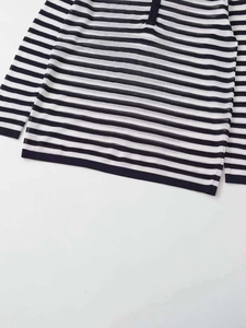 Detailed macro view of black and white striped knit fabric with button placket detail