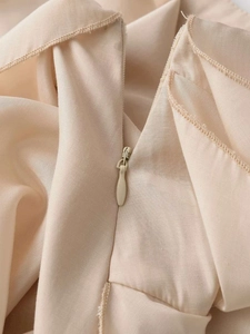 Close-up of invisible zipper and fine stitching on the beige flowy ruffled skirt