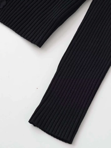 Detail shot of the ribbed knit fabric texture with elegant black lace trim on the sleeve