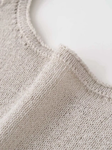 Detailed close-up of oatmeal knit vest featuring premium fine-stitch collar and soft texture