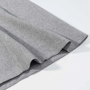 Close-up of gray melange woven fabric with elegant pleated texture on a maxi skirt