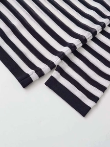 Detail of classic black and white striped knit top showing ribbed cuff and fine fabric texture