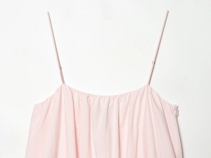 Detail of light pink mini dress showing thin straps and invisible side zipper closure