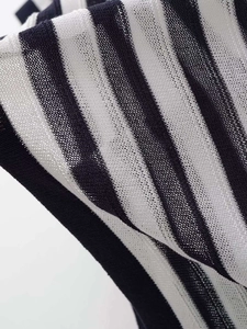 Close-up of black and white striped knit fabric with breathable hollow mesh texture
