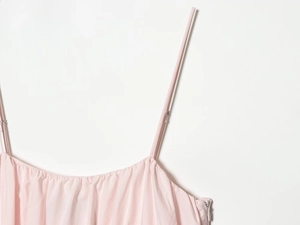 Detail of light pink mini dress with thin straps, pleated neckline and side zipper