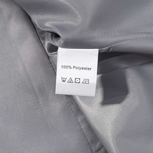 Detailed close-up showing 100% polyester fabric texture and care label of grey suit