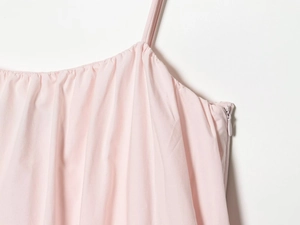 Detail of light pink mini dress featuring thin spaghetti straps and a side hidden zipper