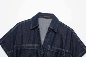 Detail of dark blue denim shirt with white contrast stitching and chest pockets