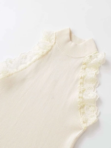 Detailed view of the off-white knit top featuring delicate lace trim on the armhole