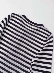 Detail view of the black and white striped knit shirt neckline and fabric texture