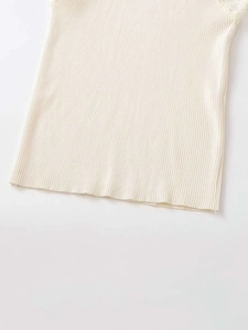 Detail of off-white ribbed knit top featuring delicate lace trim and soft texture