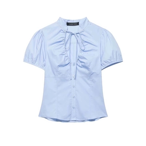 Light blue short sleeve shirt with ruffled collar, tie-front detail, and pleated design