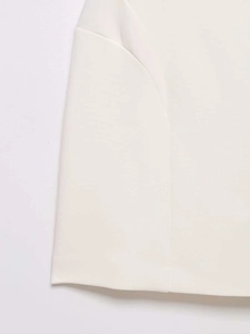 Close-up of white sleeveless dress showing hollow-out waist and premium woven texture