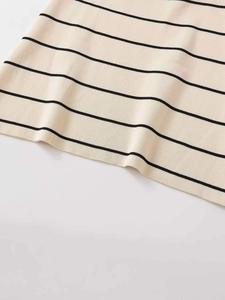 Dettaglio del tessuto in maglia beige a righe nere con cuciture fini sull'orlo