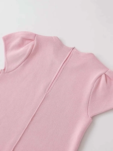 Detail of pink knit top featuring puff sleeves and smooth back zipper closure
