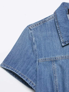 Detail of blue denim shirt showing collar structure and contrast stitching texture