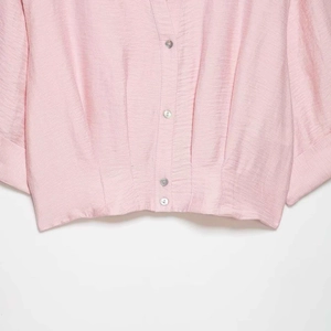 Pink V-neck satin shirt for women with pearl buttons and pleated waist detail