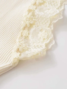 Close-up of cream ribbed knit fabric with elegant floral lace trim and delicate textures