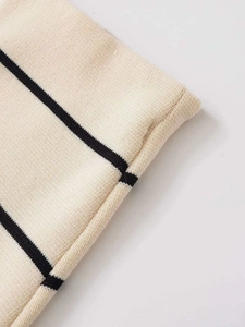 Dettaglio del tessuto in maglia crema con strisce nere e trama di cucitura di alta qualità
