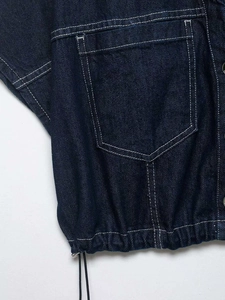 Detail of dark blue denim set with white contrast stitching and drawstring waist hem
