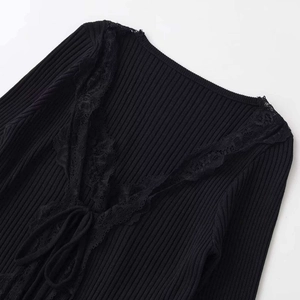 Women's black V-neck knit top with lace trim and tie-front bow detailing on white background