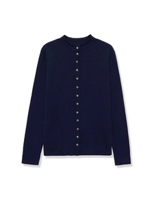 Dettaglio del cardigan in maglia blu scuro con bottoni bianchi e decorazione a volant