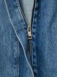Detailed macro view of vintage metal zipper and texture on a blue denim jacket