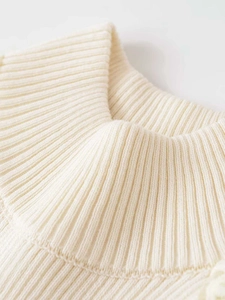 Close-up of cream ribbed knit neckline texture and soft fabric details on tank top