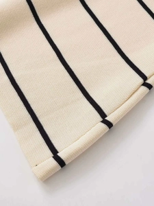 Dettaglio ravvicinato del tessuto in maglia fine con base crema e strisce nere