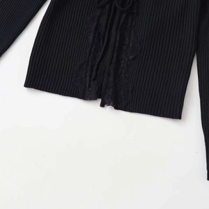 Women's black V-neck ribbed knit top featuring delicate lace splicing and front tie detail