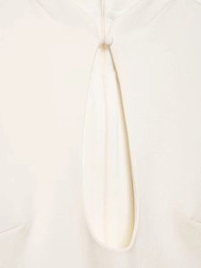 Detail of white sleeveless dress with keyhole cutout and fabric-covered button